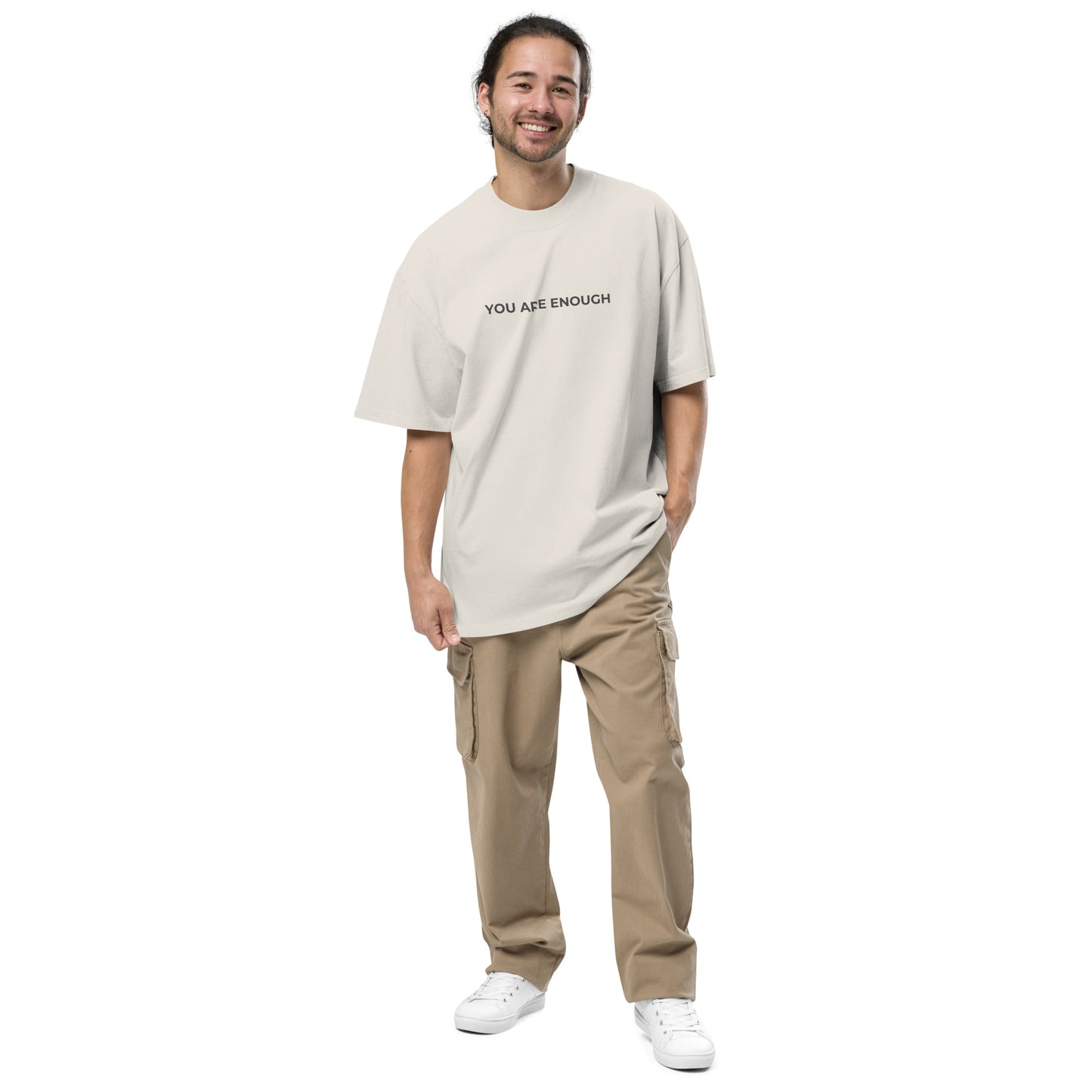 Man wearing a faded bone oversized faded tee in light beige with "You Are Enough" text.