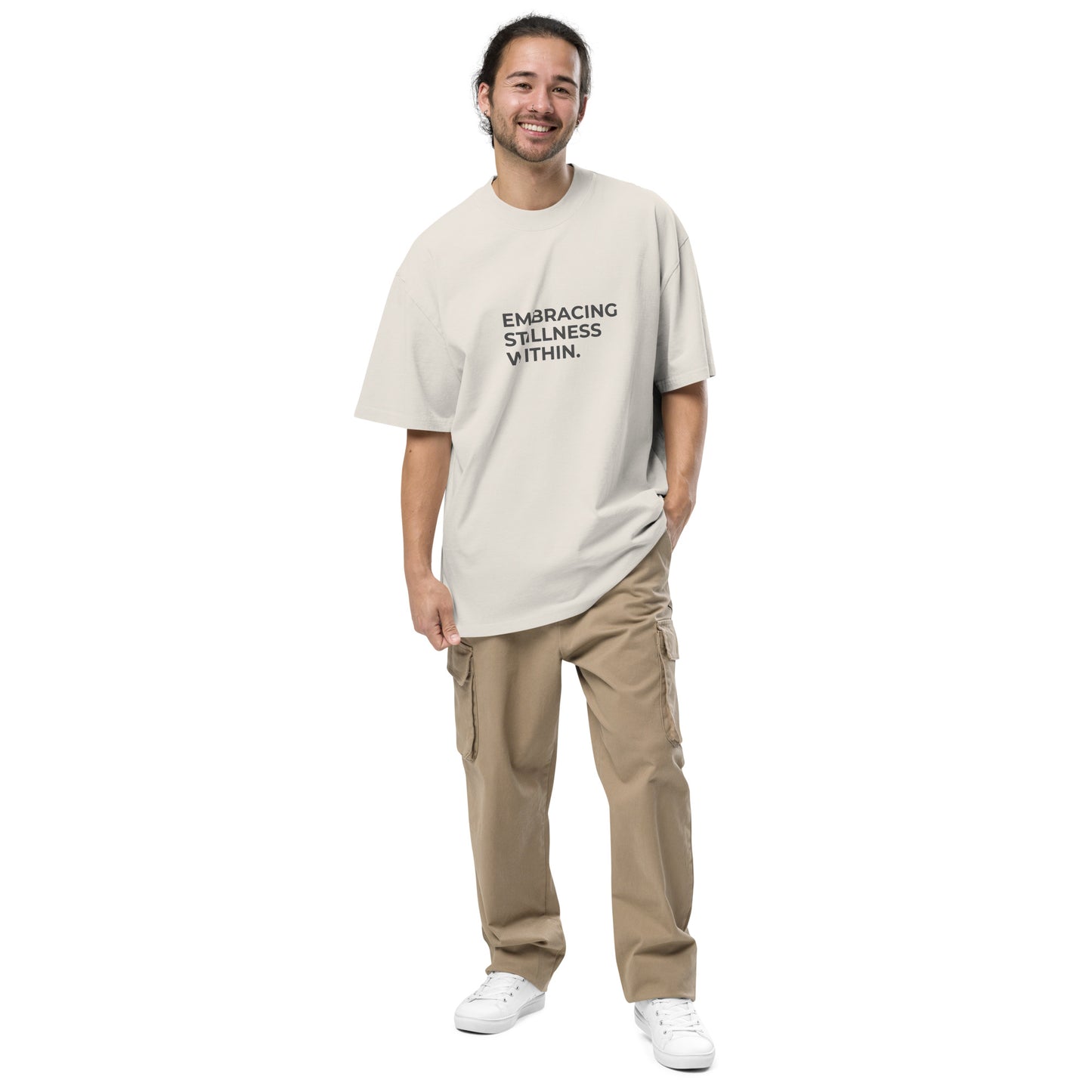 Man wearing a faded bone oversized faded tee with "Embracing Stillness Within" text.