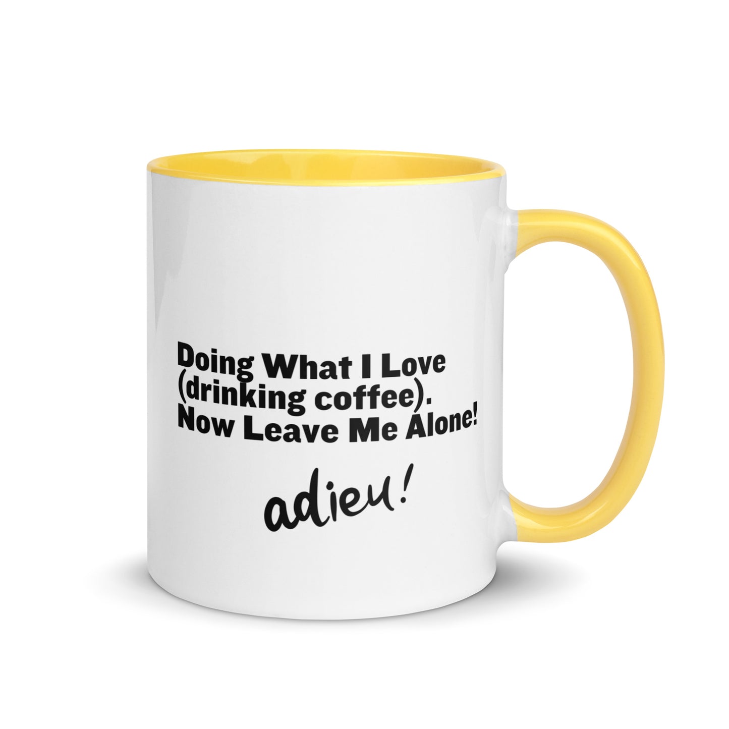A while ceramic mug with yellow on the inside and on the handle with the words, "Doing what I love (drinking coffee). Now Leave Me Alone!"