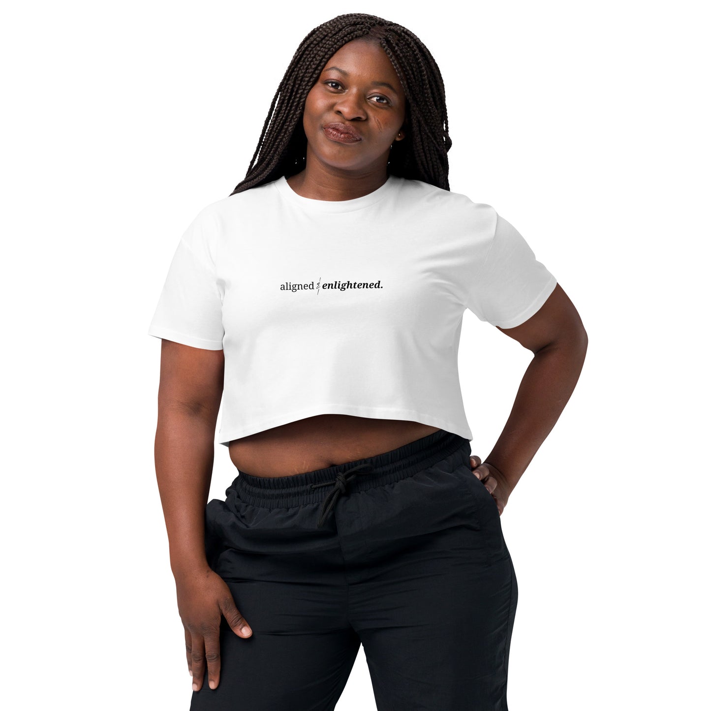 Woman wearing a white cropped t-shirt with the phrase "aligned & enlightened" printed in black, smiling and posing against a clean background. Available in various colors: black, brown, pink, green, and white. Sizes range from XS to XL.