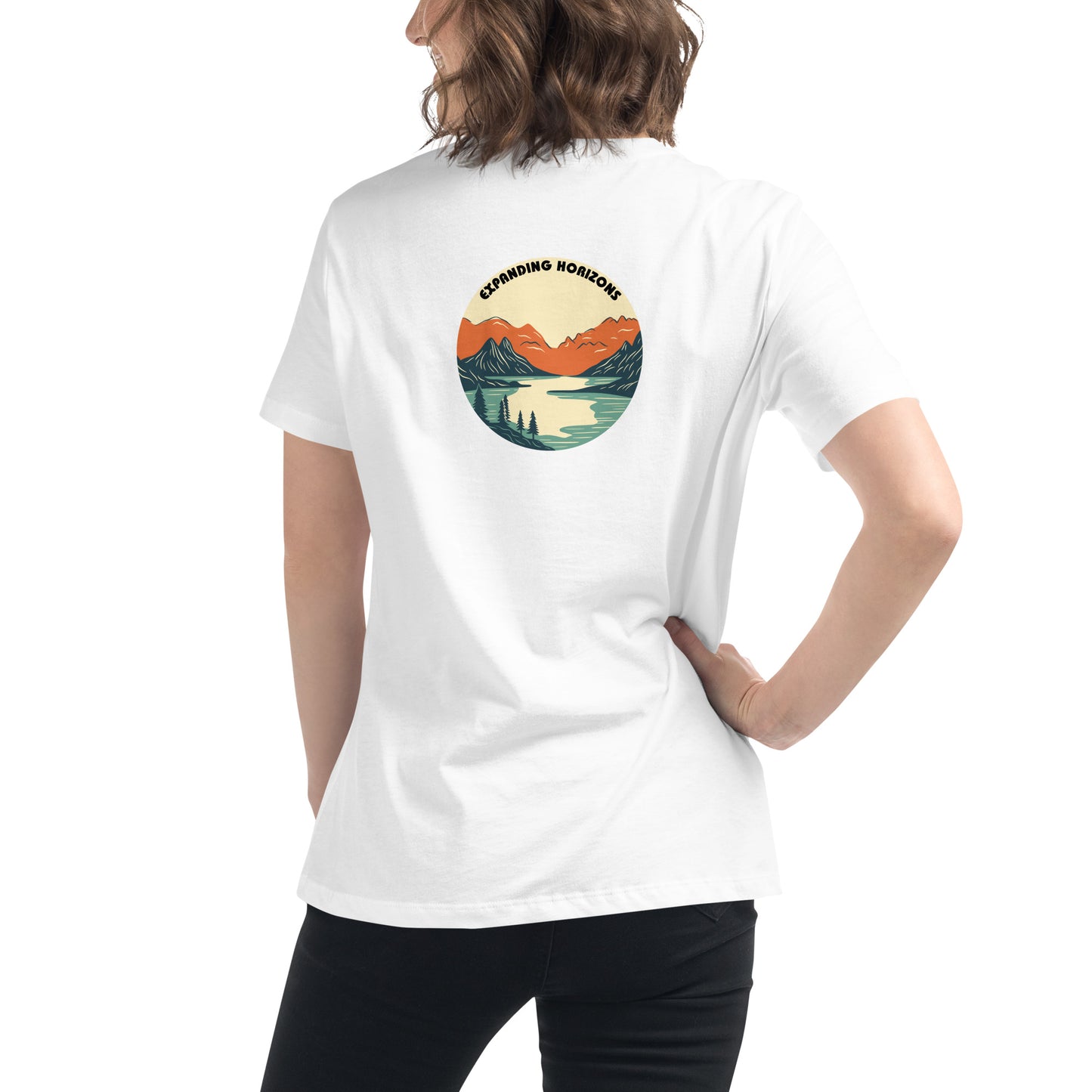 Woman wearing a white relaxed t-shirt featuring a scenic mountain and lake design with 'Expanding Horizons' text