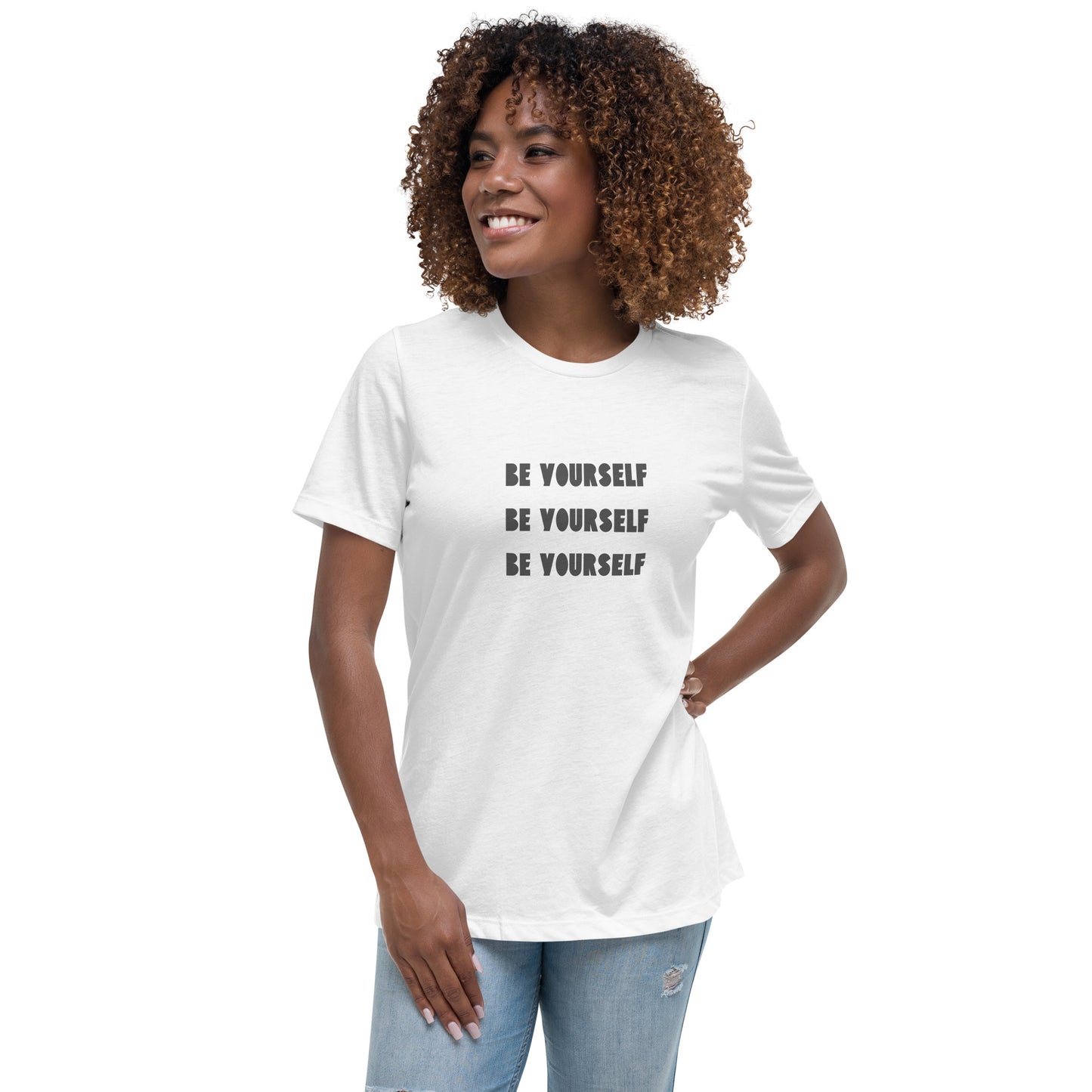 Smiling woman wearing a white relaxed t-shirt with 'Be Yourself' text repeated