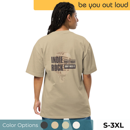 Rear view of a woman in a taupe oversized T-shirt with 'INDIE ROCK Party Night' event promotion graphic, size range S to 3XL displayed, matched with blue jeans, reflecting a casual and musical lifestyle theme