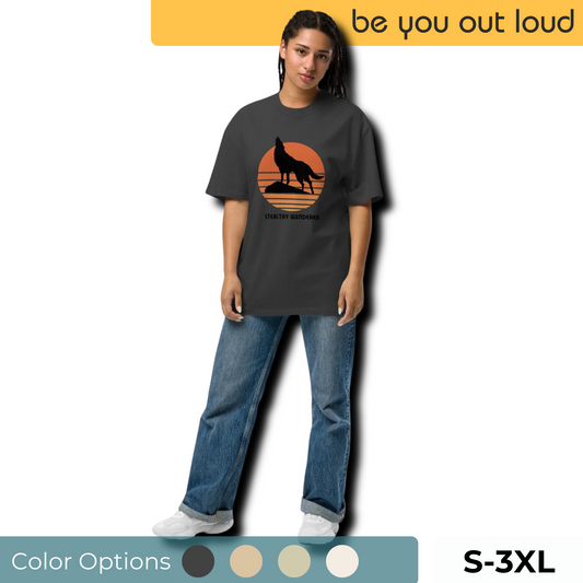 Model sports Be You Out Loud's "Stealthy Wanderer" oversized t-shirt in charcoal, featuring a striking wolf silhouette against a moon backdrop, available in size S-3XL with color palette options.