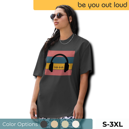 Cool woman wearing a charcoal graphic t-shirt with a retro headphone and soundwave design, available in diverse color options and sizes S to 3XL, embracing the 'be you out loud' spirit.