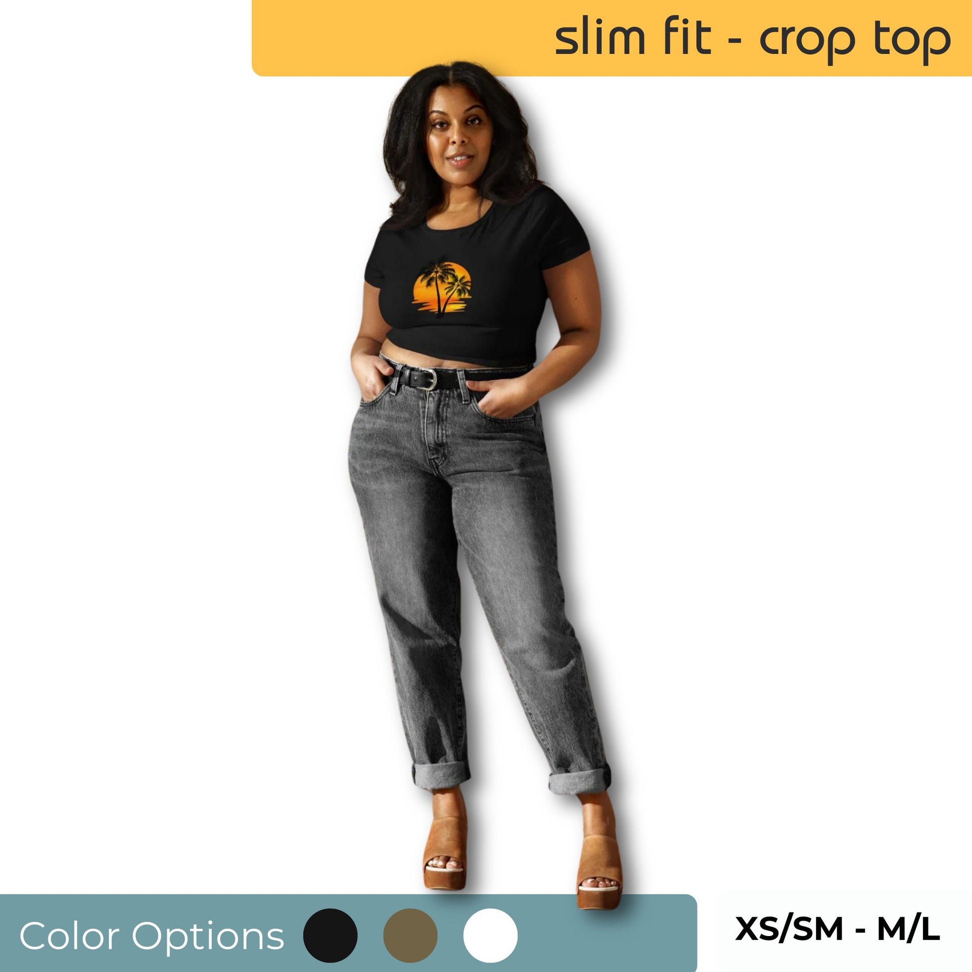 Woman sporting a black slim fit crop top with a vibrant sunset and palm tree graphic, complemented by rolled-up gray jeans and tan heels, with size and color options displayed.