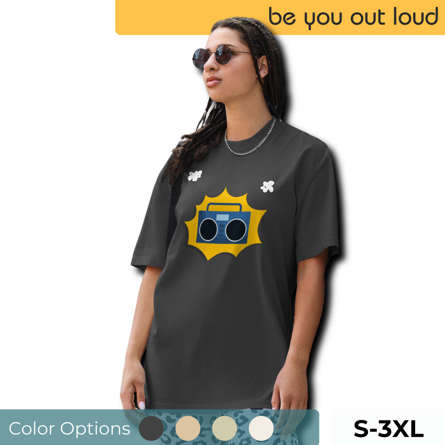 Woman wearing a charcoal grey oversized tee with a bold, yellow graphic of a classic boombox, available in sizes S to 3XL, offering a timeless addition to a quirky wardrobe.