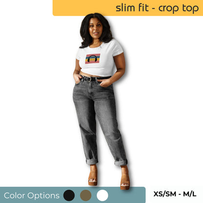 Woman wearing a Be You Out Loud Slim Fit White Crop Top with a Pride Rainbow graphic, paired with grey jeans and brown sandals, available in XS/SM to M/L sizes.