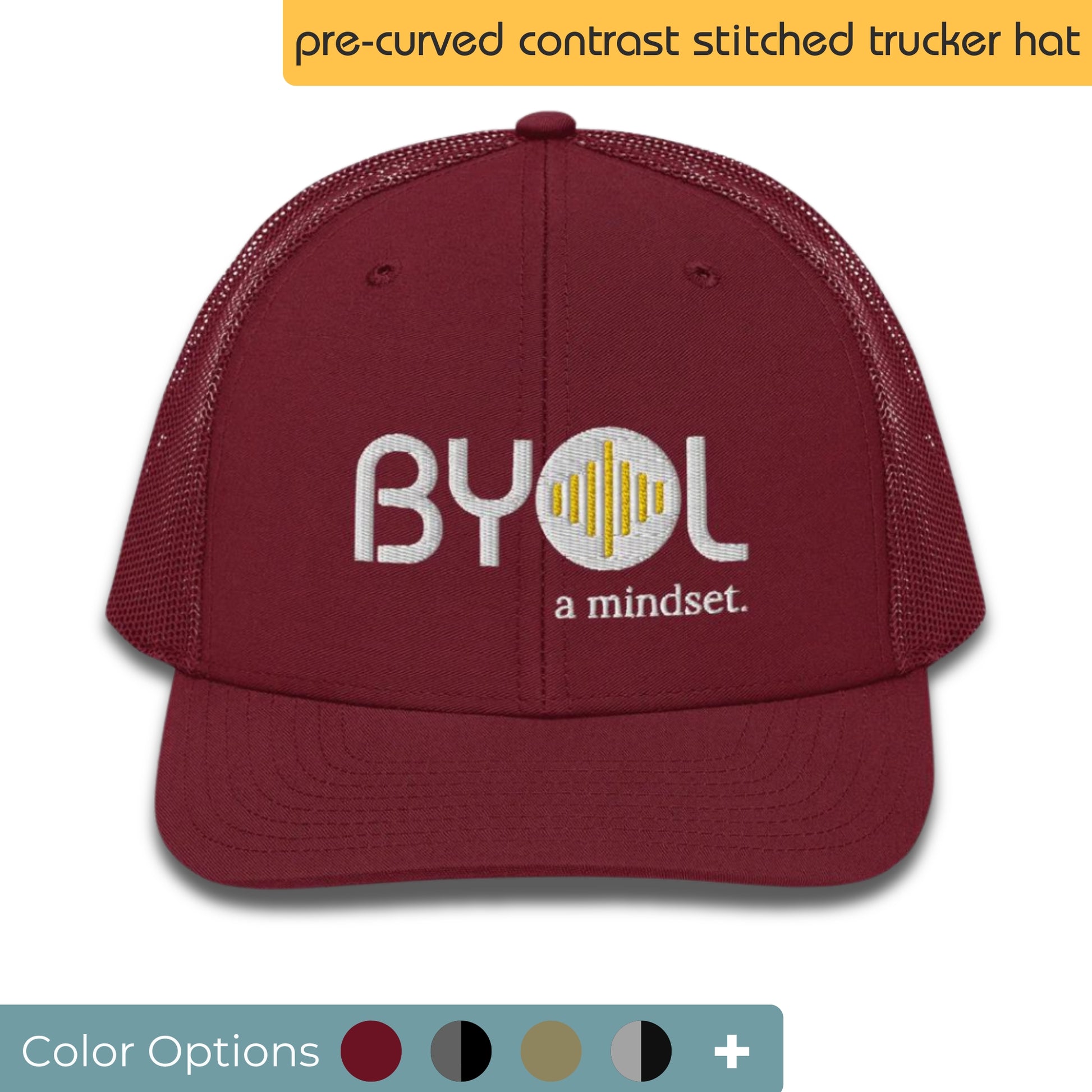 Maroon pre-curved contrast stitched trucker hat with "BYOL a mindset" embroidered on the front in white and yellow, displayed against a clean background. Available in various colors: maroon, black, green, and gray.