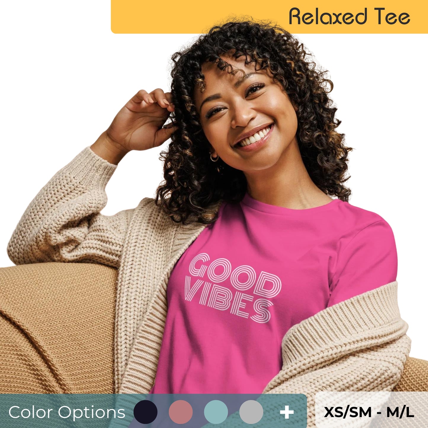 Radiant woman with curly hair wearing a vibrant pink relaxed tee with 'Good Vibes' in white letters, paired with a beige cardigan, available in multiple colors, sizes XS/SM to M/L