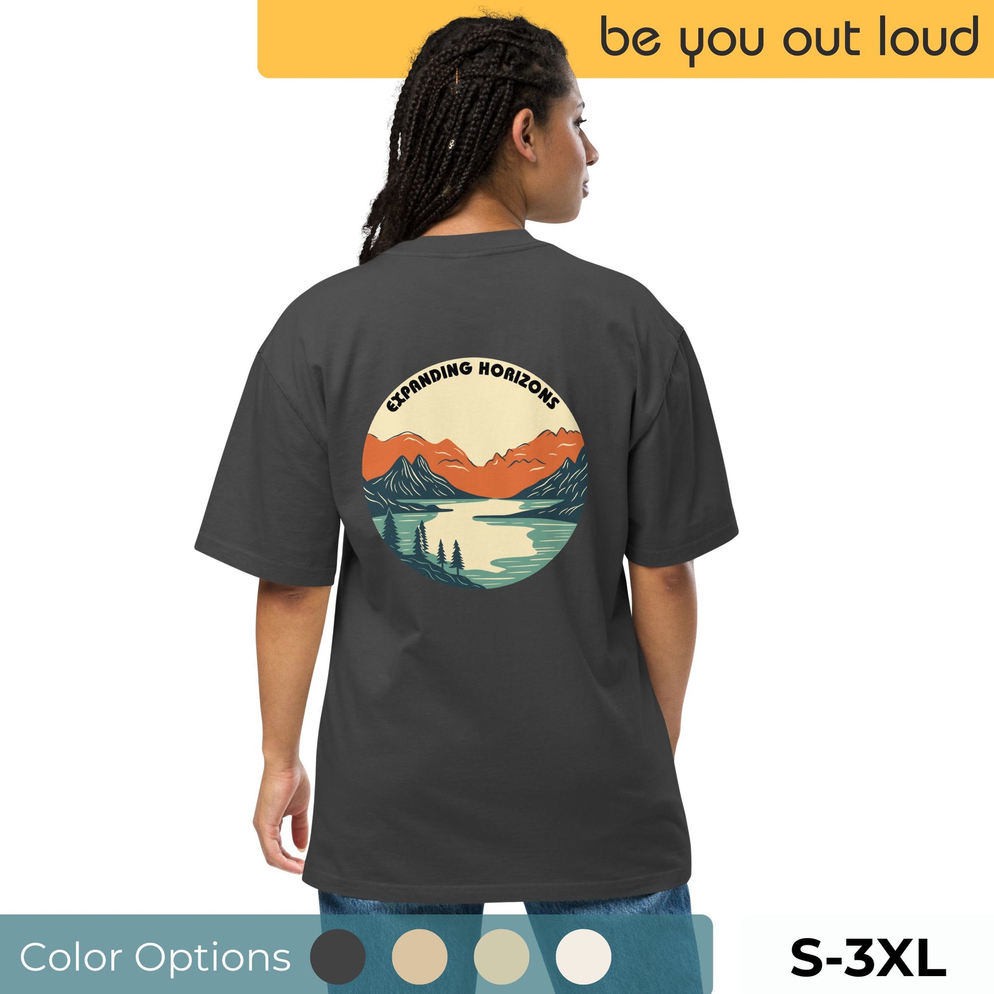 Woman in Be You Out Loud's Expanding Horizons Oversized Tee with a captivating mountain and lake graphic, signaling a love for adventure and nature, sizes S-3XL.