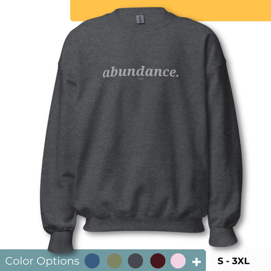 Dark gray sweatshirt with the phrase "abundance." printed on the front, available in color options navy blue, green, maroon, gray, and pink, available in sizes S to 3XL.