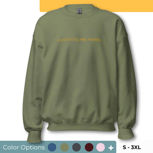 military Green sweatshirt with the phrase "manifesting my reality." printed on the front, available in color options navy blue, green, maroon, gray, and pink, available in sizes S to 3XL.