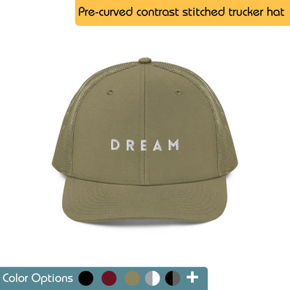 Green trucker hat with the word "DREAM" embroidered in white on the front. Text "Pre-curved contrast stitched trucker hat" is written above the image, and "Color Options+" is written below the image.