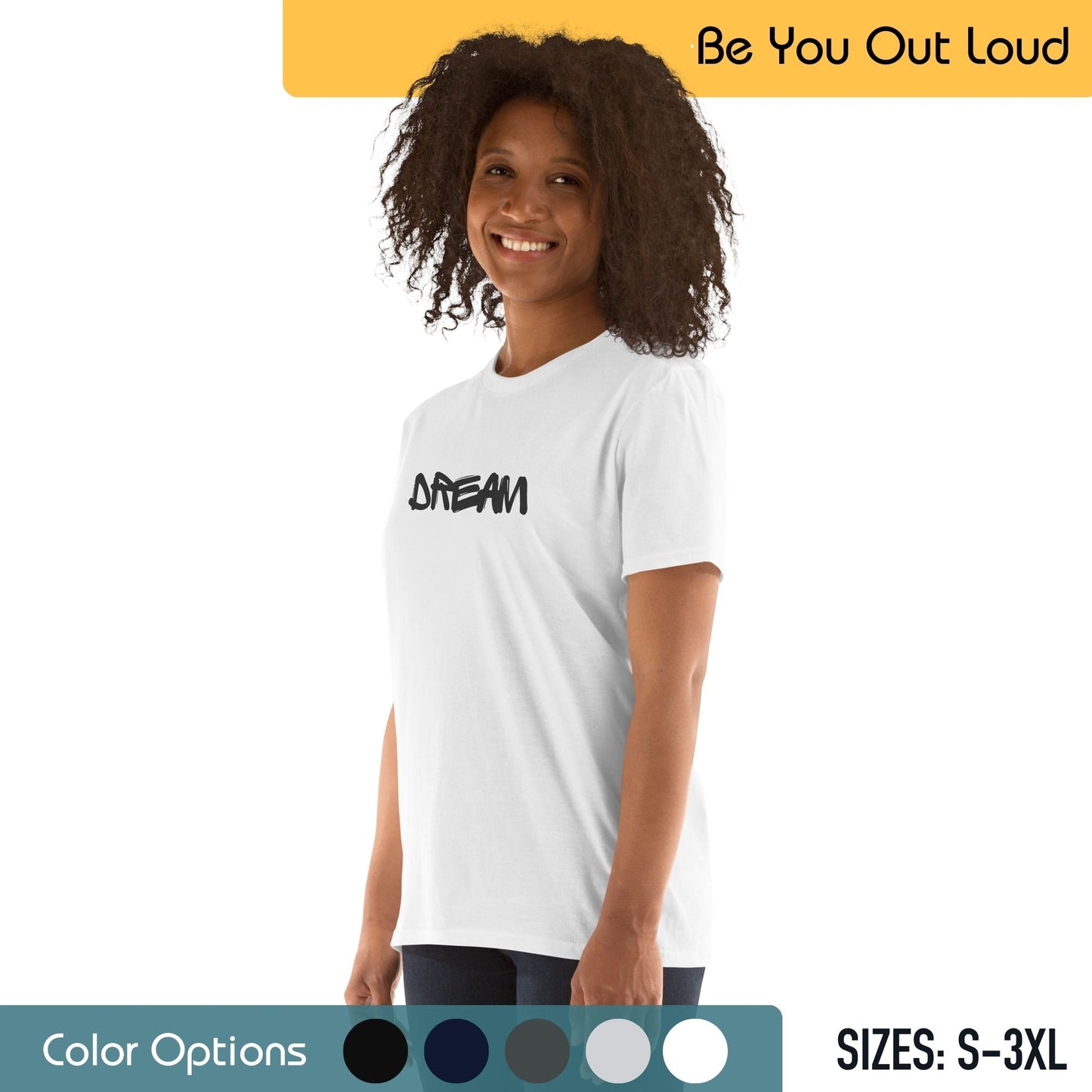 A smiling woman with curly hair wearing a white T-shirt with the word "DREAM" printed in bold letters. The background includes the phrase "Be You Out Loud," a selection of color swatches, and a size chart showing available sizes from S to 3XL.