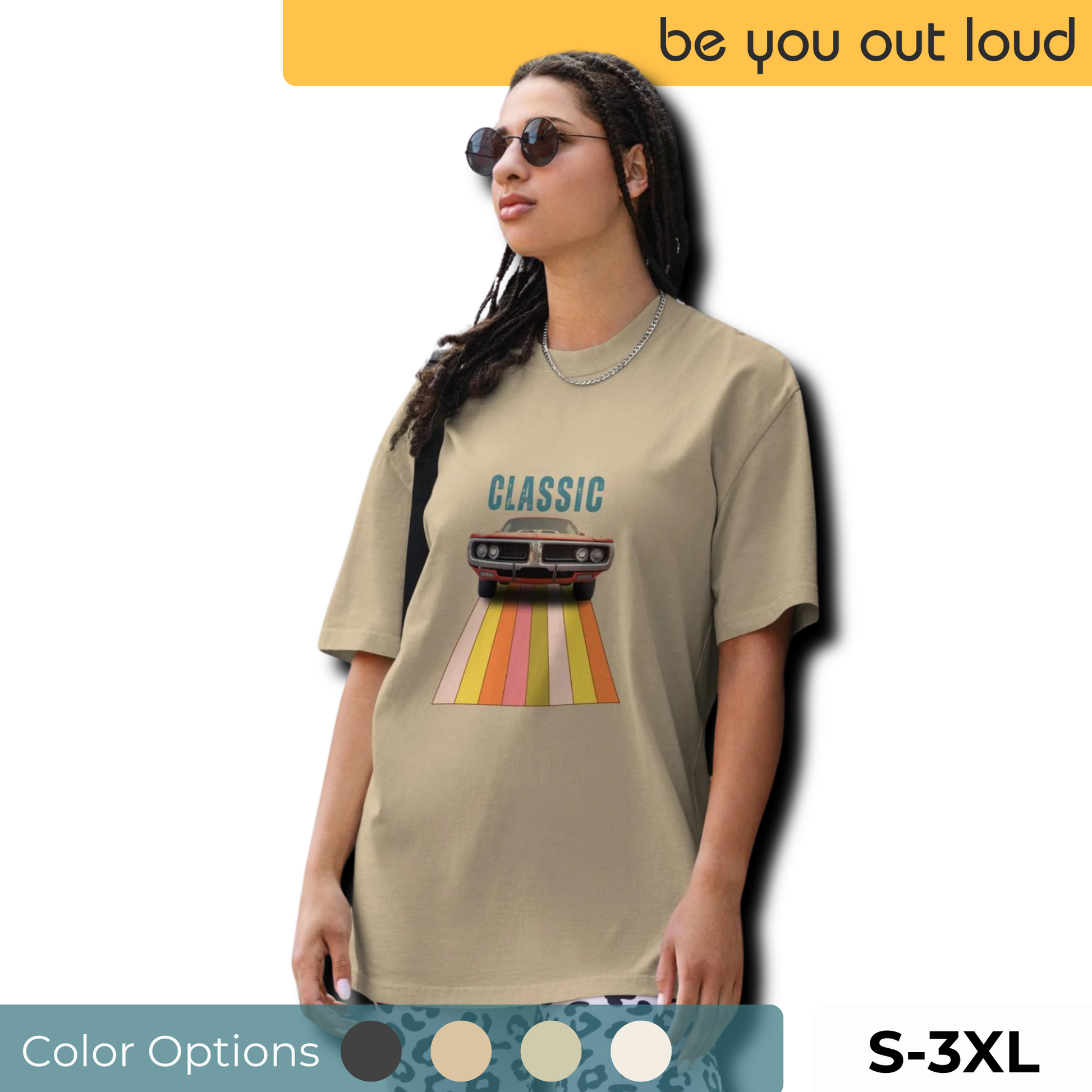 Cool and casual, a woman models a beige 'CLASSIC' graphic tee featuring a vintage car cruising down a retro striped road, part of the 'Be You Out Loud' series, available in sizes S to 3XL, complemented by a selection of color swatches and paired with relaxed blue jeans and chic sunglasses.