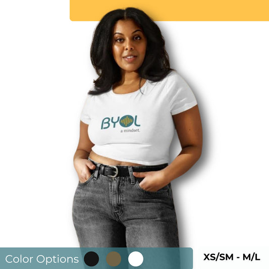 Woman wearing a BYOL mindset crop top in white with color options in black, brown, white, and blue, available in sizes XS/SM to M/L.