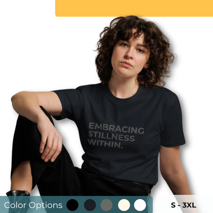 Woman wearing a dark grey premium tee with "Embracing Stillness Within" text, available in multiple colors and sizes S-3XL.