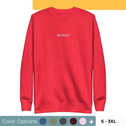 Red embroidered "Be Bold" premium crew neck sweatshirt with soft fleece lining, ribbed cuffs, and hem, available in various colors and sizes.