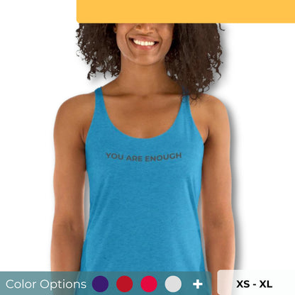 Smiling woman wearing a blue racer back tank with "You Are Enough" text, available in multiple colors and sizes.