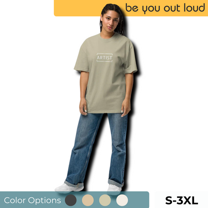 A relaxed yet stylish woman wears a Women's ARTIST Oversized Tee in olive green, paired with blue jeans and white sneakers, showcasing the shirt's understated design. Available in sizes S-3XL with additional color options presented below.