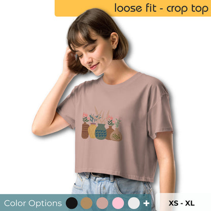 Woman wearing a loose-fit crop top with a charming vase floral graphic design, embodying comfortable and authentic fashion by BYOL. Showing multiple color and size options available