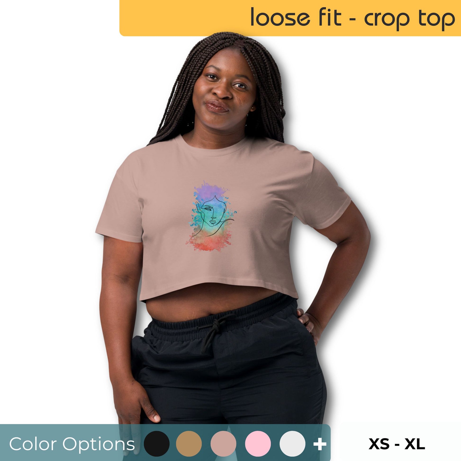 Confident woman posing with hand on hip, wearing a taupe loose-fit crop top featuring a colorful abstract face design, matched with black pants, against a backdrop with color swatches indicating available options and a size range from XS to XL.