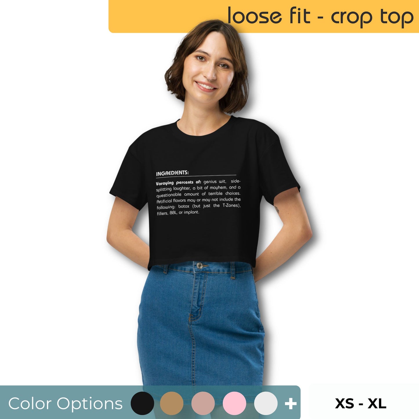 Smiling woman in a black loose-fit crop top with humorous 'Ingredients' list graphic, paired with a blue denim skirt, offering a playful yet stylish outfit choice along with various color swatches and sizes XS to XL.