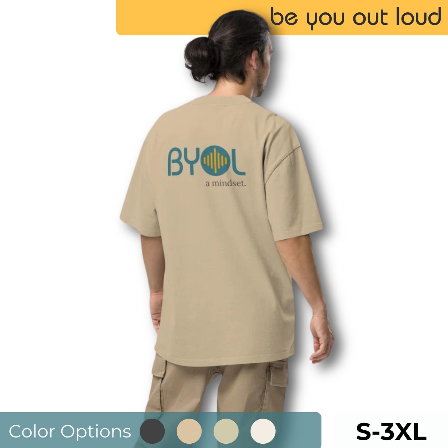 A young man with long hair in a ponytail wearing a light tan "BYOL: a mindset" T-shirt, viewed from the back. The T-shirt features the "BYOL" logo in teal and yellow on the back and is available in multiple colors (dark gray, beige, light blue) and sizes (S-3XL). The "be you out loud" logo is displayed at the top.