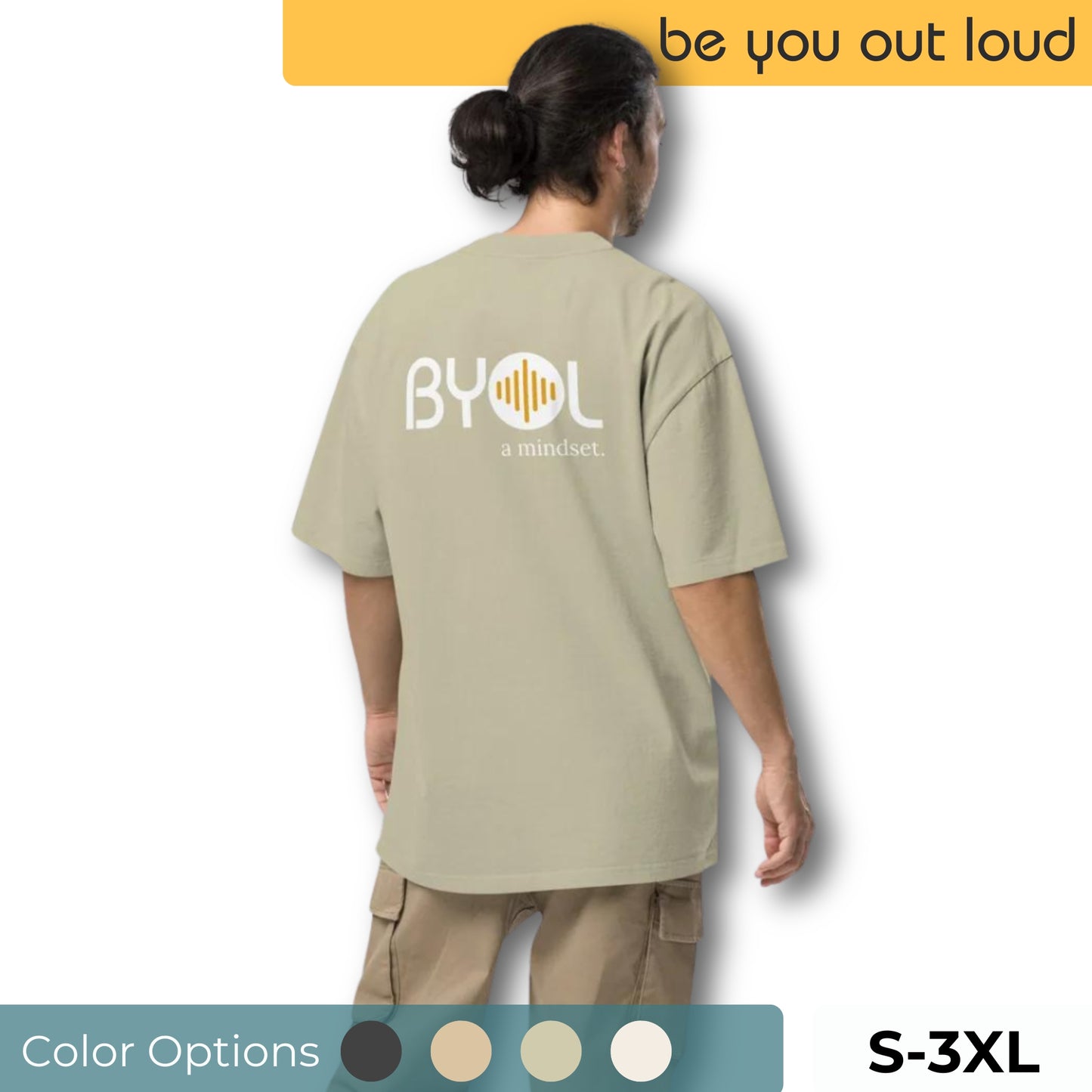 A young man with long hair in a ponytail wearing a light beige "BYOL: a mindset" T-shirt, viewed from the back. The T-shirt features the "BYOL" logo on the back and is available in multiple colors (dark gray, beige, light blue) and sizes (S-3XL). The "be you out loud" logo is displayed at the top.