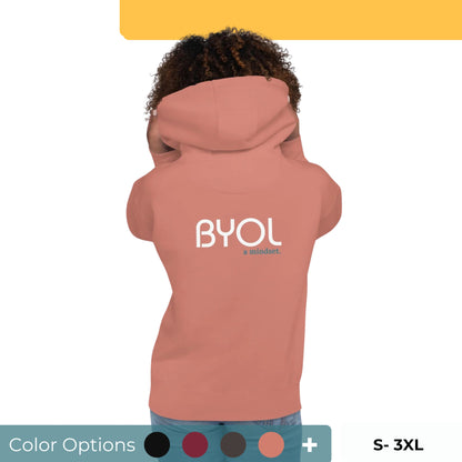 Back view of a woman wearing a pink BYOL mindset hoodie with color options in black, maroon, dark gray, and light pink, available in sizes S to 3XL.