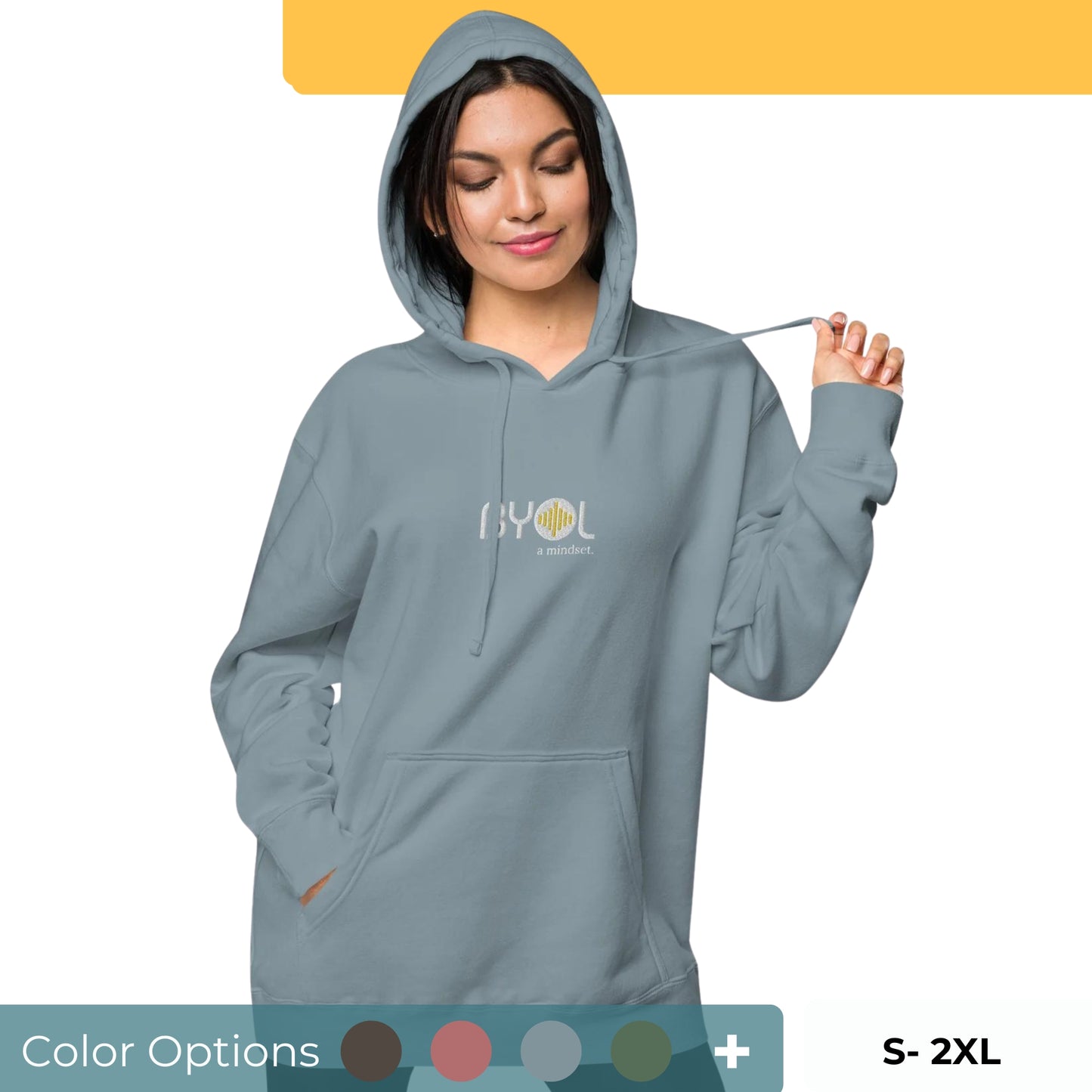 Woman wearing a pigmented blue BYOL mindset hoodie with color options in brown, pink, gray, and green, available in sizes S to 2XL.