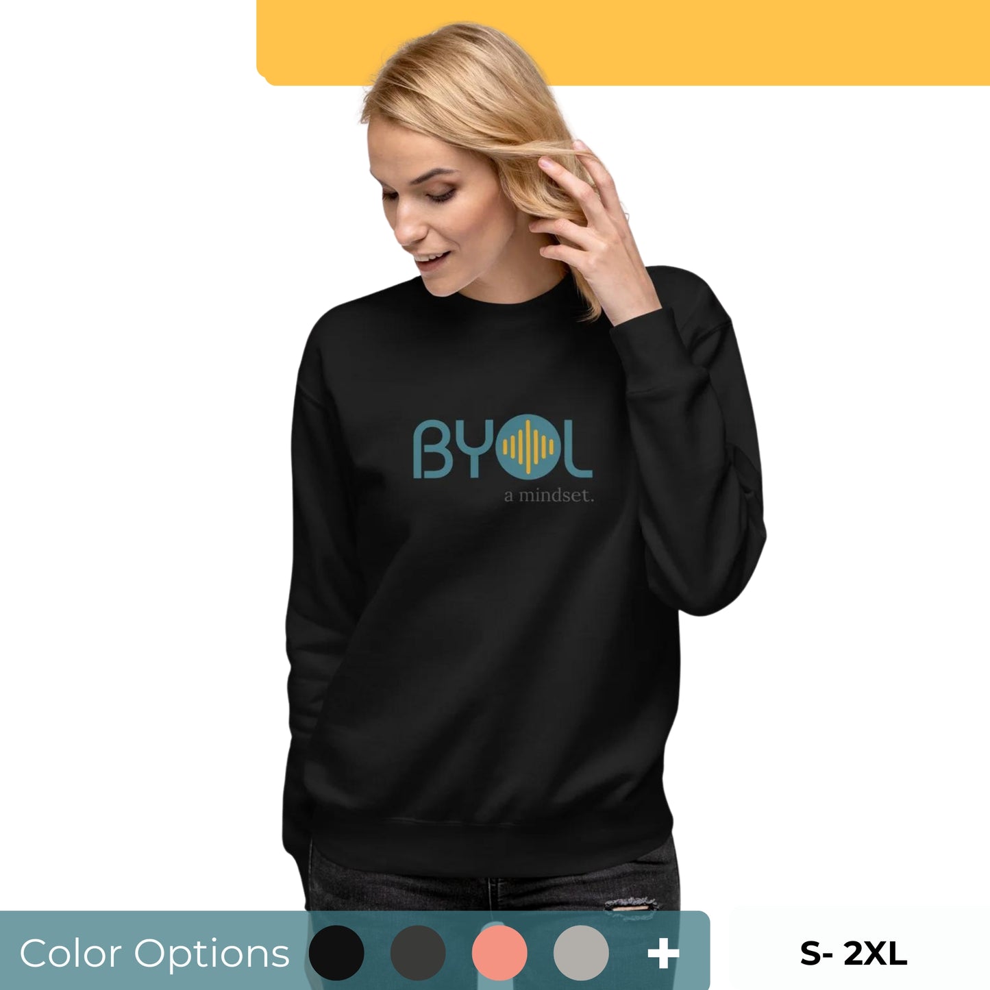 Woman wearing a black BYOL mindset sweatshirt with color options in black, dark gray, pink, and light gray, available in sizes S to 2XL.