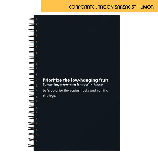 Notebook page with a sarcastic definition of the corporate jargon phrase "prioritize the low-hanging fruit," described as choosing the easiest tasks and labeling it a strategy, emphasizing a humorous critique of superficial business practices.