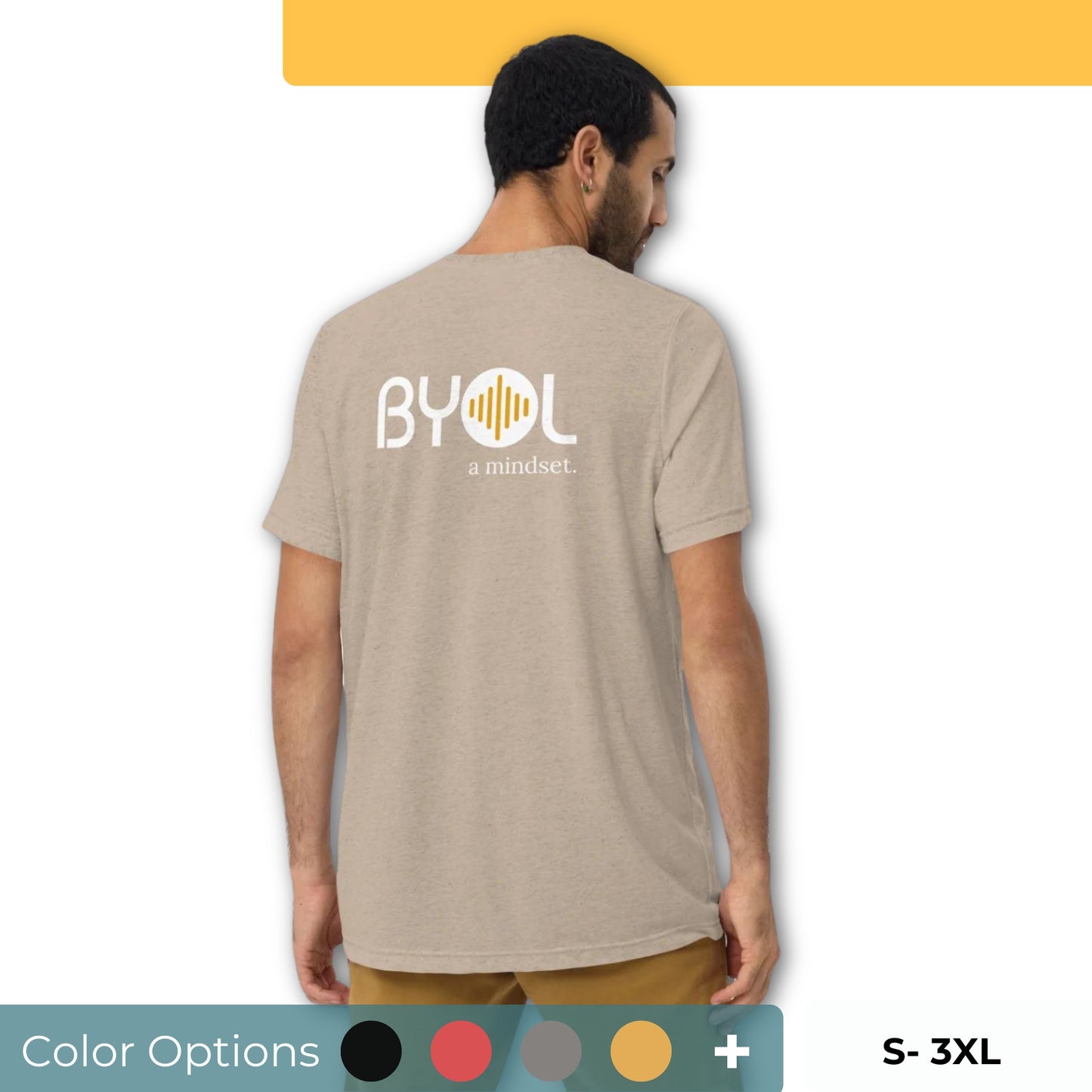 A young man with short dark hair wearing a beige "BYOL: a mindset" T-shirt, viewed from the back. The T-shirt features the "BYOL" logo in white and yellow on the back and is available in multiple colors (black, red, gray, pink, beige, plus more) and sizes (S-3XL). The "be you out loud" logo is displayed at the top.