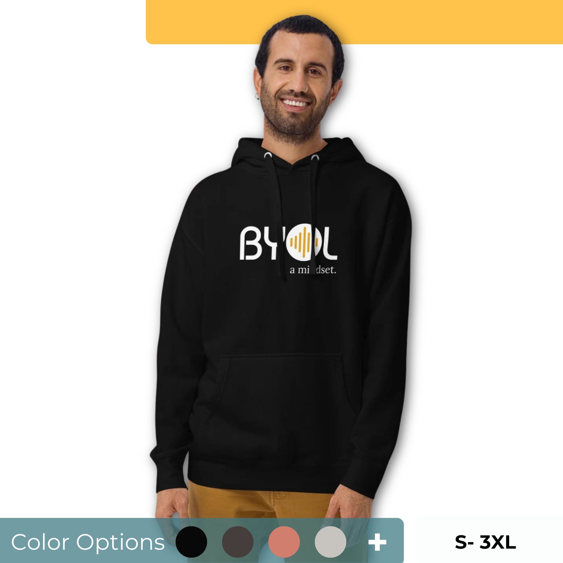 A young man with short hair and a beard wearing a black "BYOL: a mindset" hoodie, smiling and standing with his arms at his sides. The hoodie features the "BYOL" logo in white and yellow on the front and is available in multiple colors (black, dark gray, maroon, pink, light gray, plus more) and sizes (S-3XL). The "be you out loud" logo is displayed at the top.