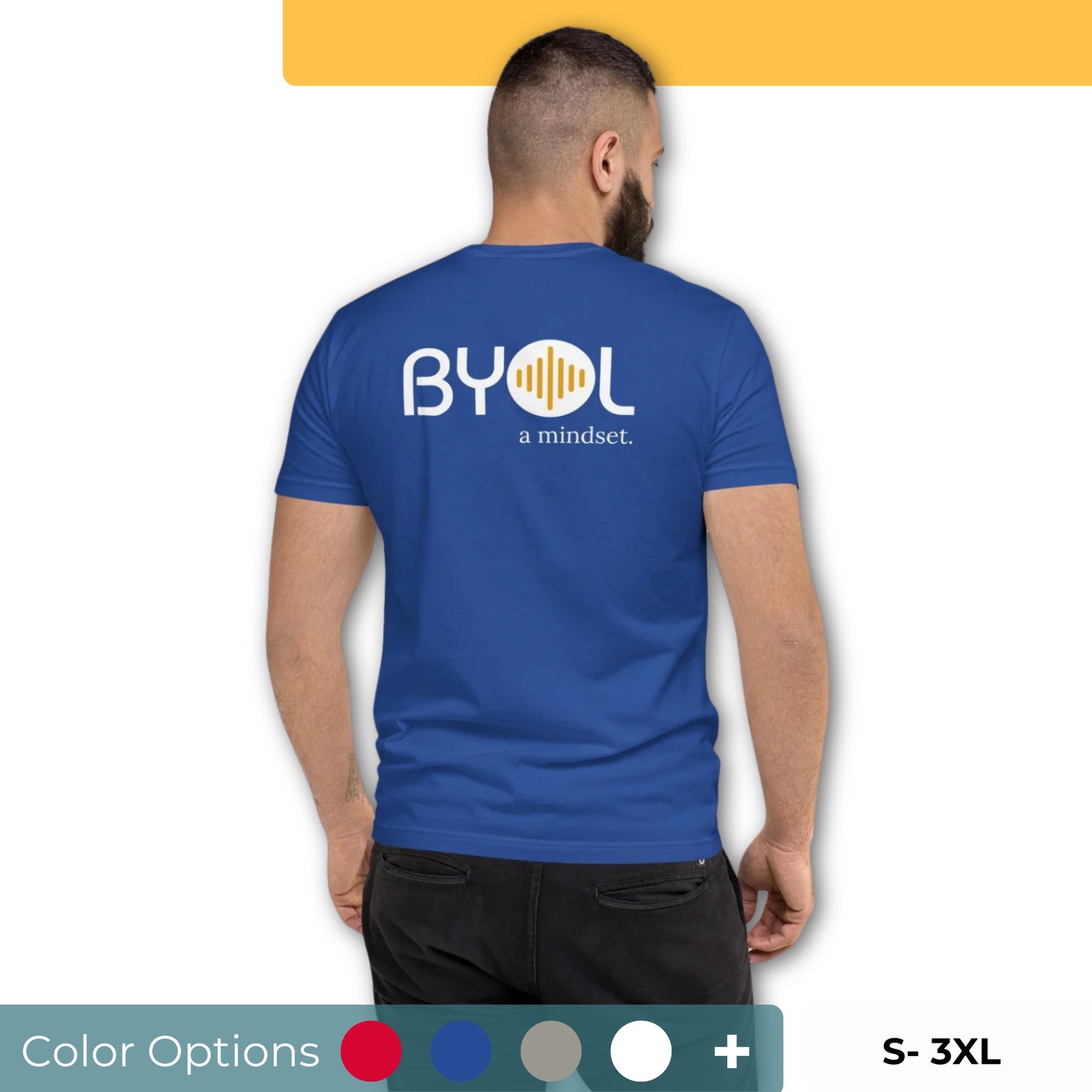 A young man with short dark hair and a beard wearing a royal blue "BYOL: a mindset" T-shirt, viewed from the back. The T-shirt features the "BYOL" logo in white and yellow on the back and is available in multiple colors (red, blue, gray, white, plus more) and sizes (S-3XL). The "be you out loud" logo is displayed at the top.