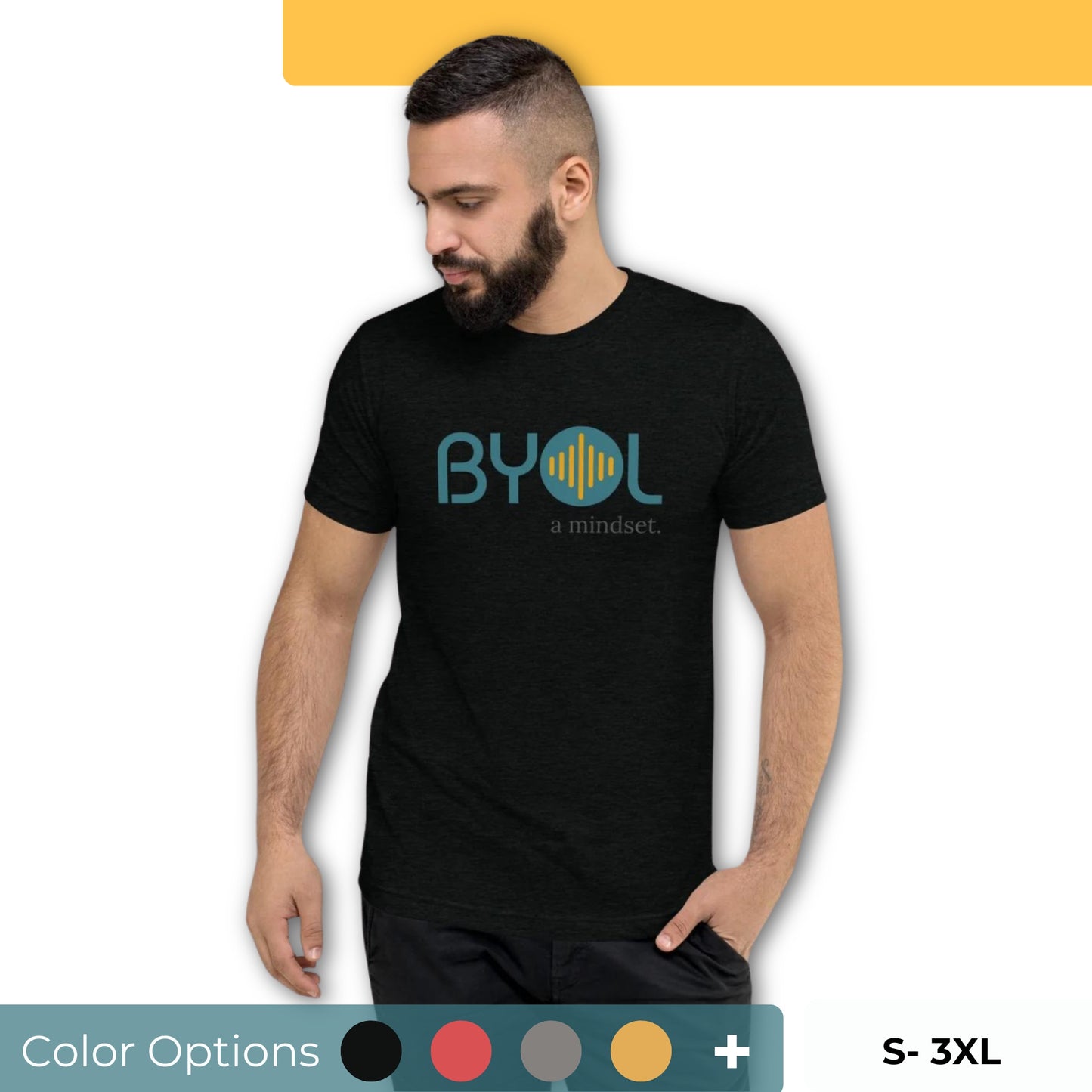 A young man with short dark hair and a beard wearing a black "BYOL: a mindset" T-shirt, standing with one hand in his pocket and looking down. The T-shirt features the "BYOL" logo in blue and yellow on the front and is available in multiple colors (black, red, gray, pink, gold, plus more) and sizes (S-3XL). The "be you out loud" logo is displayed at the top.