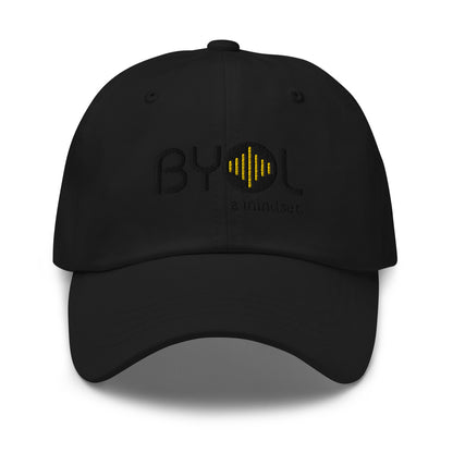 Black classic dad hat with "BYOL a mindset" embroidered on the front in black and yellow, displayed against a clean background. Available in various colors: black, gray, green, pink, and white.