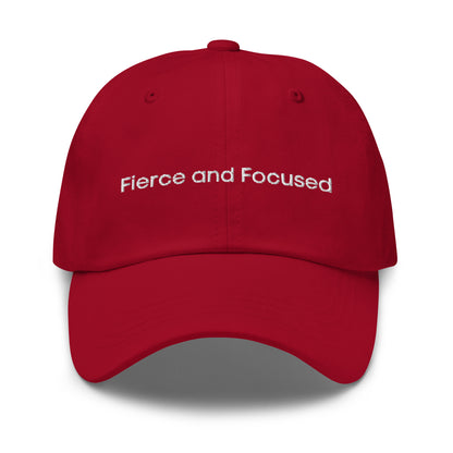 A red dad hat with the phrase "Fierce and Focused" embroidered in white stitching across the front.