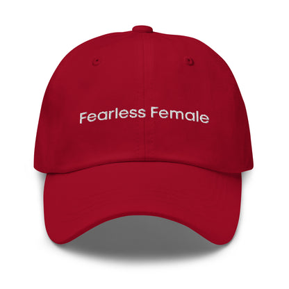 A red dad hat with the phrase "Fearless Female" embroidered in white stitching across the front.