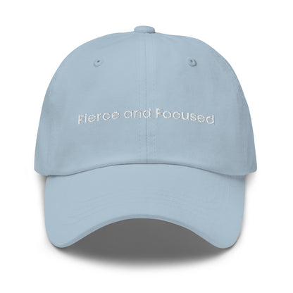 A light blue dad hat with the phrase "Fierce and Focused" embroidered in white stitching across the front.