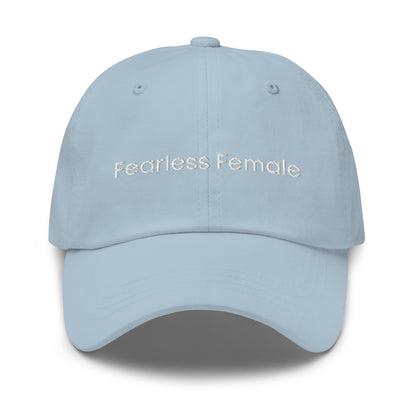 A light blue dad hat with the phrase "Fearless Female" embroidered in white stitching across the front.