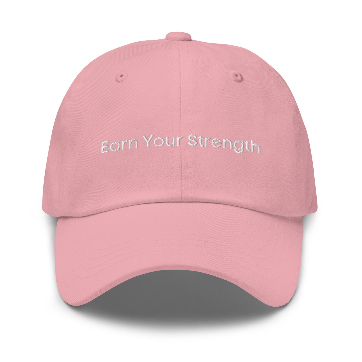 A pink dad hat with the phrase "Earn Your Strength" embroidered in white stitching across the front.