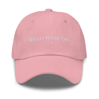 A pink dad hat with the phrase "Beast Mode On" embroidered in white stitching across the front.