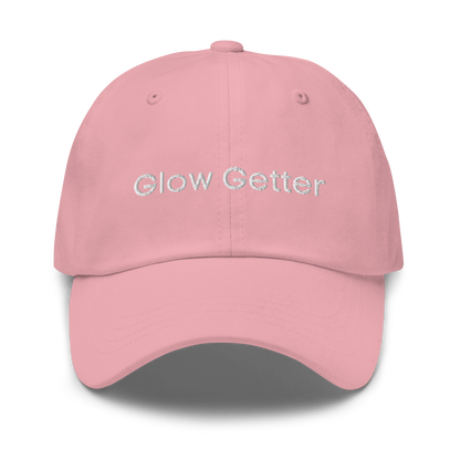 Pink baseball cap with white embroidered text 'Glow Getter' on the front.