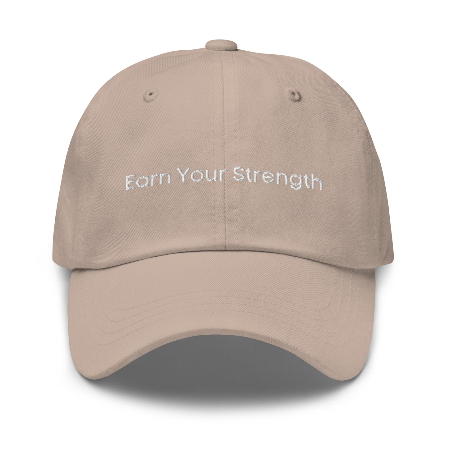 A stone dad hat with the phrase "Earn Your Strength" embroidered in white stitching across the front.