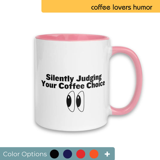 White coffee mug with a pink handle and interior, playfully printed with "Silently Judging Your Coffee Choice" and cartoon eyes, appealing to humor-loving coffee drinkers, showcased with various color customization options.