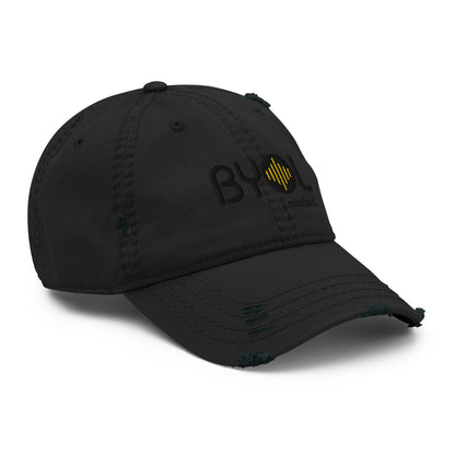 Black distressed dad hat with "BYOL a mindset" embroidered on the front in black and yellow, featuring intentional wear and tear details, displayed against a clean background. Available in various colors: black, navy blue, gray, green, and beige.