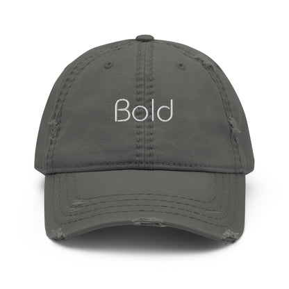 A grey dad hat with a slightly distressed brim and crown, featuring the word "Bold" embroidered in white on the front.